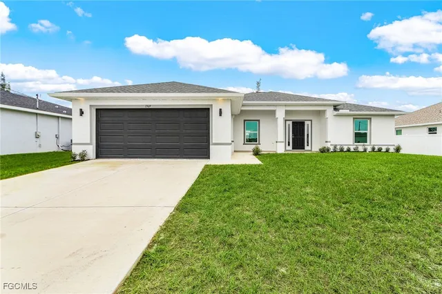 a front view of a house with a yard and trees