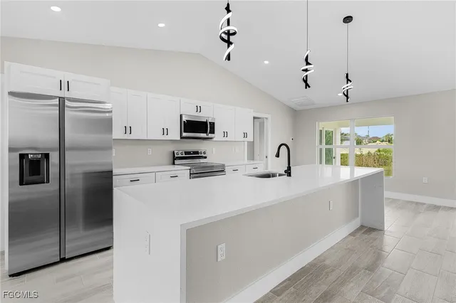 a kitchen with stainless steel appliances a refrigerator sink and microwave