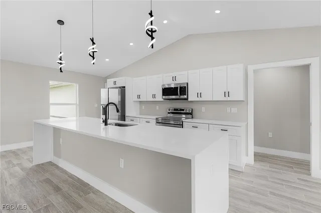 a kitchen with kitchen island a sink stainless steel appliances and cabinets