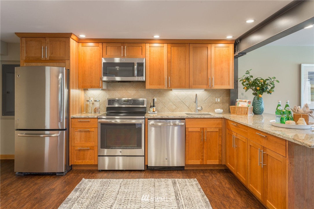 3500 West Commodore Way Seattle, WA 98199 - Photo 20 of 25 a kitchen with granite countertop stainless steel appliances a refrigerator sink and microwave