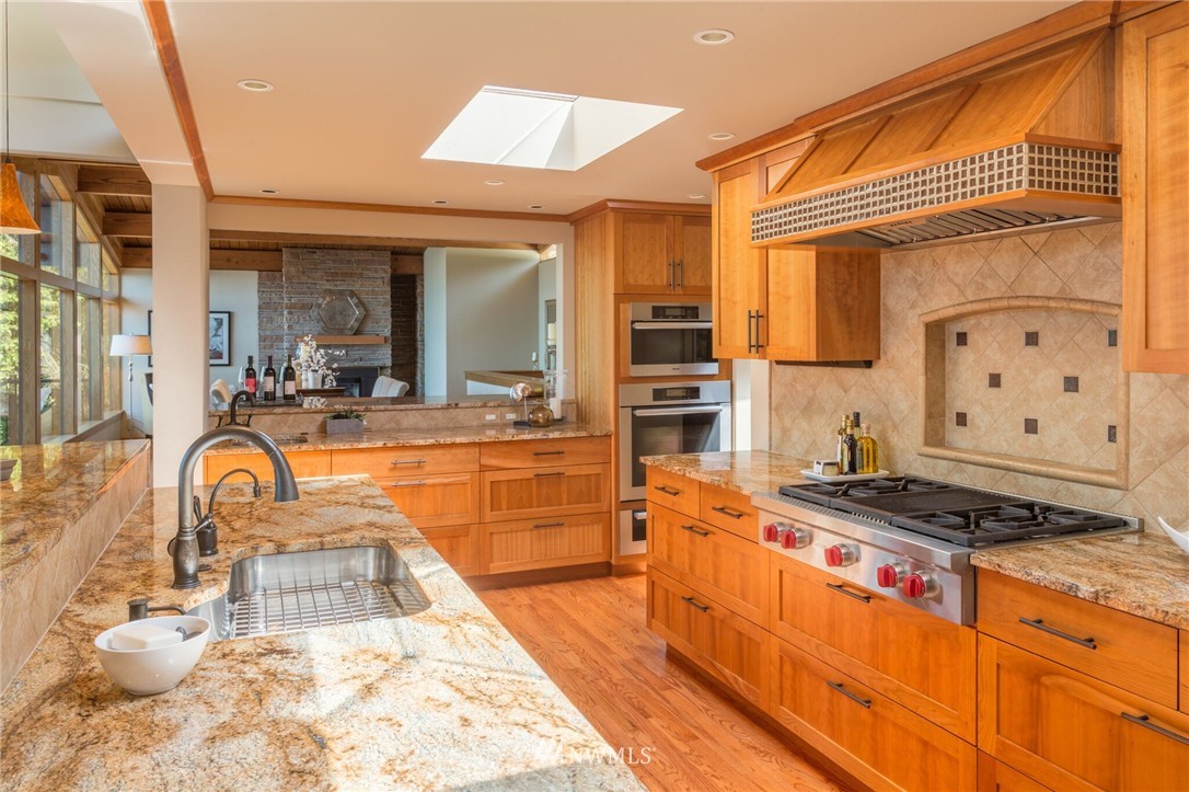 3500 West Commodore Way Seattle, WA 98199 - Photo 7 of 25 a view of a kitchen with kitchen island stainless steel appliances a stove and a large window