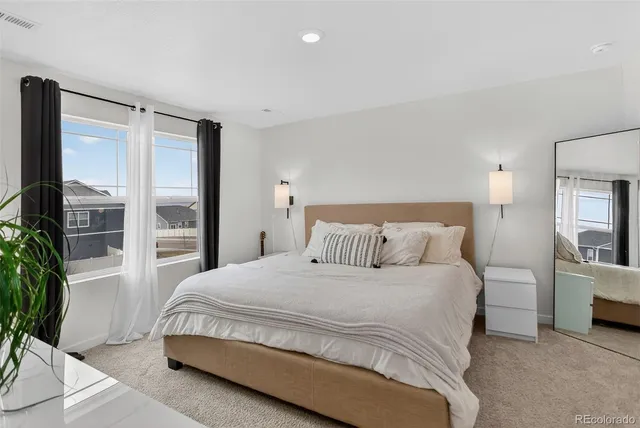 a bedroom with a large bed and a potted plant