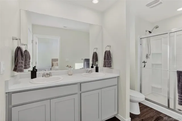 a bathroom with a double vanity sink toilet and shower