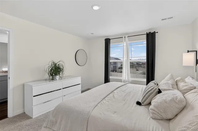a bedroom with a large bed and a potted plant