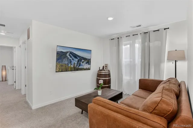a living room with furniture a large window and a flat screen tv