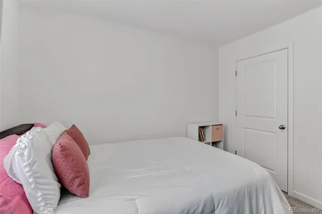 a bedroom with a bed and a white wall