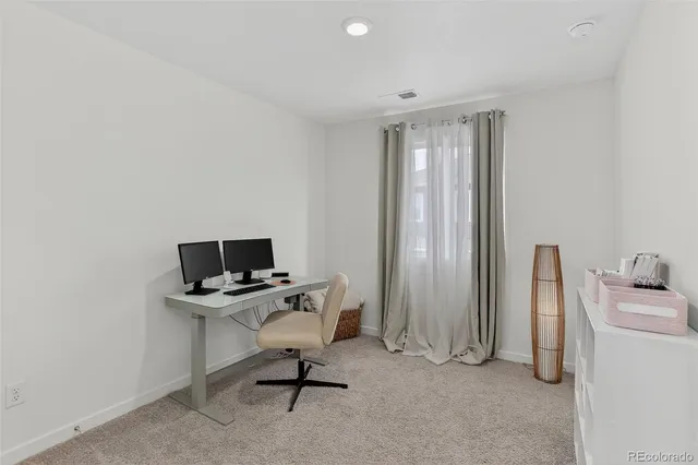 a view of a workspace with furniture and a window