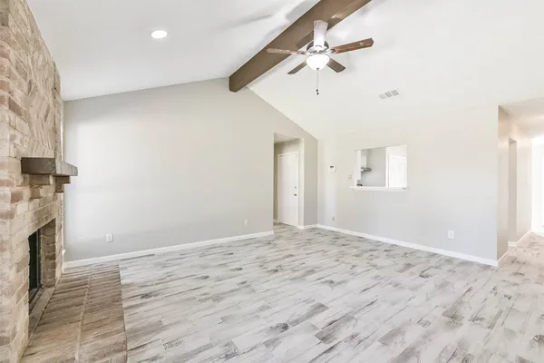 a view of empty room with a fireplace and fan