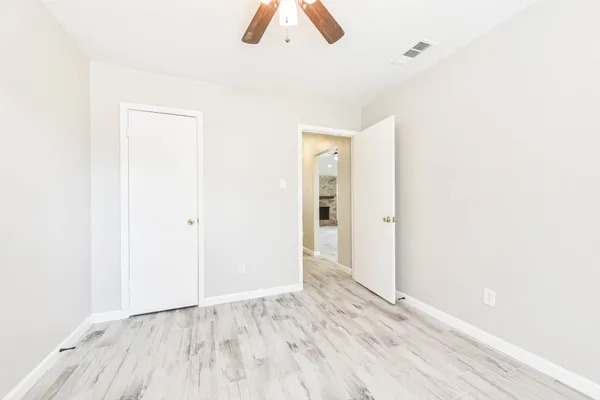 a view of an empty room with wooden floor