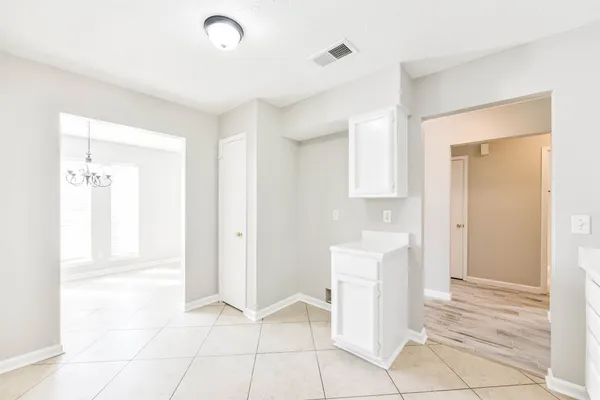 a view of a kitchen with white cabinets and entryway
