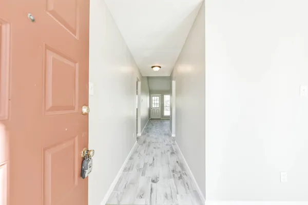 a view of a hallway with wooden floor