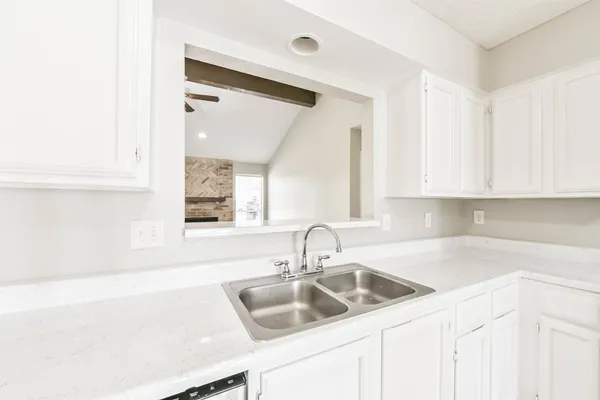 a kitchen with granite countertop a sink and cabinets