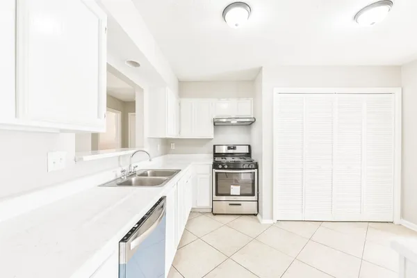 a kitchen with stainless steel appliances a sink stove and cabinets