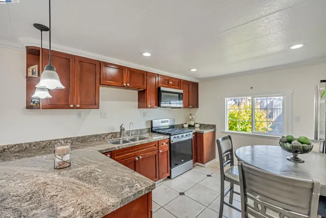 a kitchen with stainless steel appliances granite countertop a sink stove and refrigerator