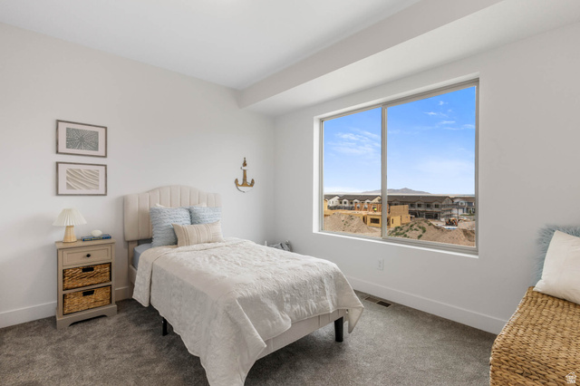 636 West Caroles Way, Unit 7 Tooele, UT 84074 - Photo 17 of 31 Spacious room featuring a large window, plush gray carpet, white walls, and a recessed ceiling detail