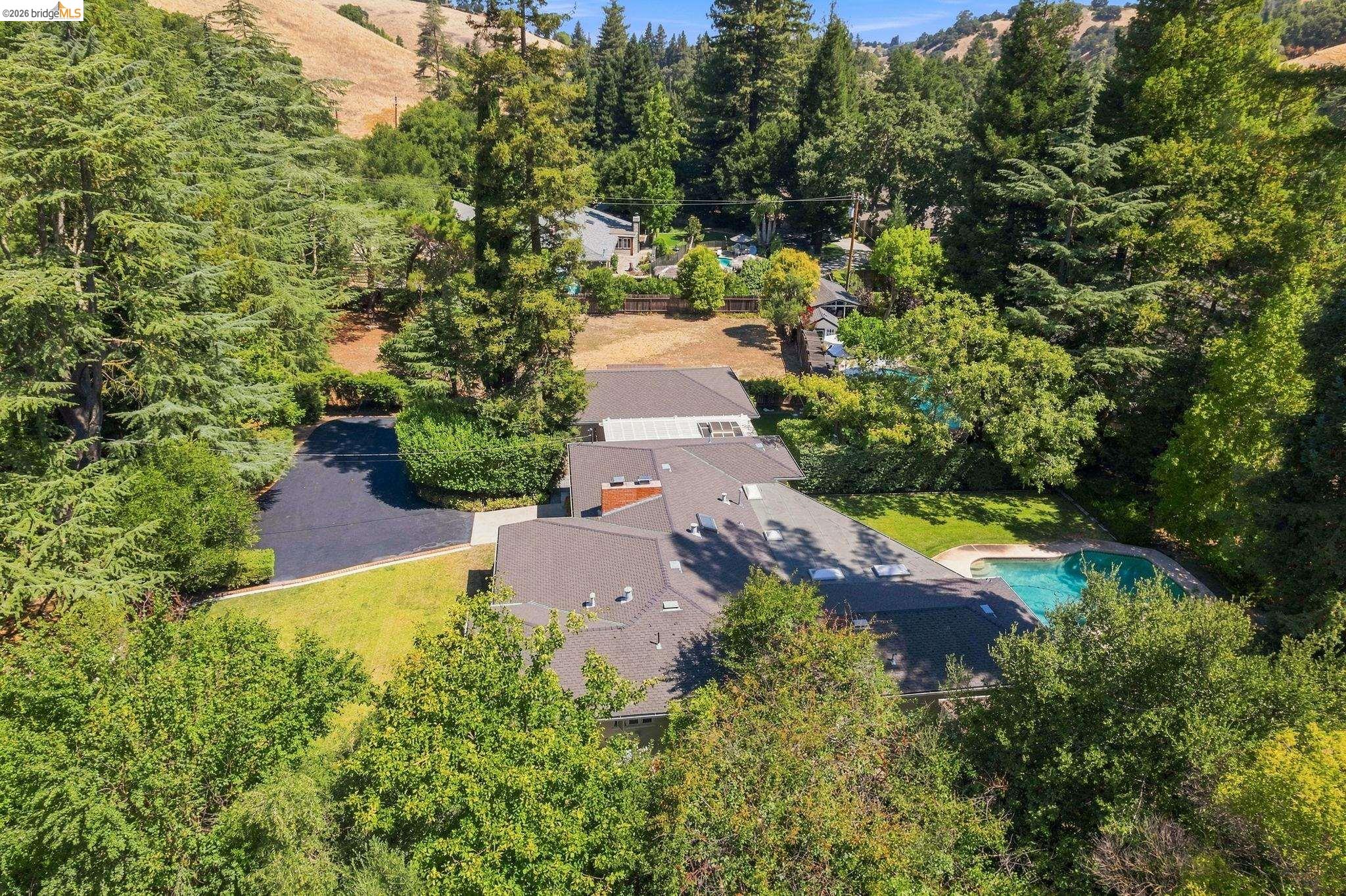 5075 Alhambra Valley Road Martinez, CA 94553 - Photo 68 of 68 Expansive property featuring a dark asphalt driveway, lush green lawn, mature trees, and a swimming pool