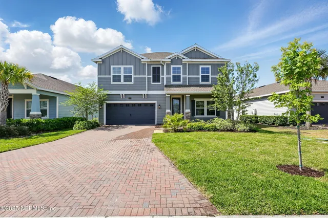 a front view of a house with a yard and trees
