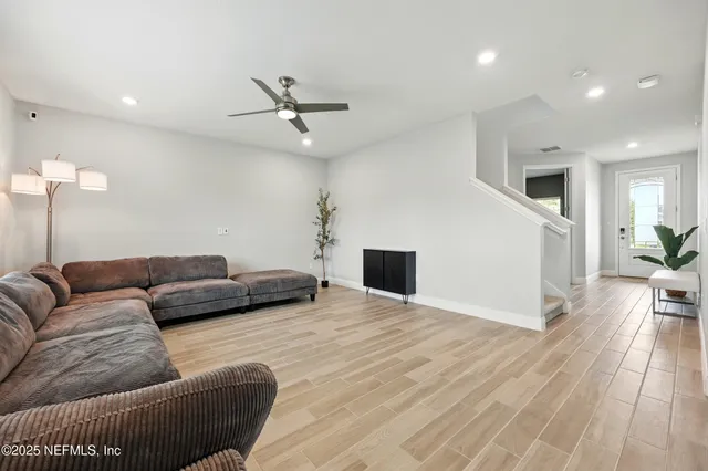 a living room with furniture and a wooden floor
