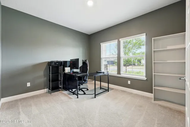 a view of a workspace with furniture and a window