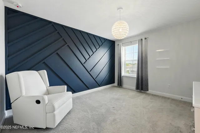 a view of an empty room with a window and a kitchen