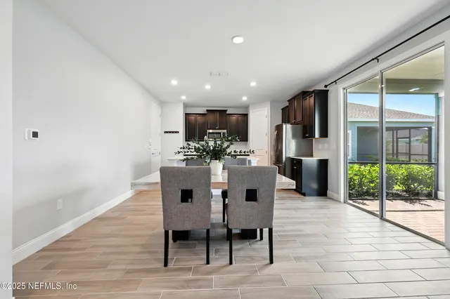a view of a dining room with furniture wooden floor and a floor to ceiling window