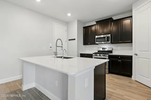 a kitchen with stainless steel appliances a sink stove and refrigerator