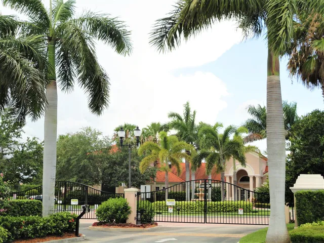 a view of a big house in front of a big yard with plants and large trees