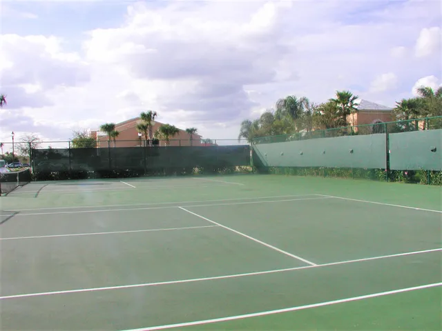 a front view of a house with a yard and palm trees