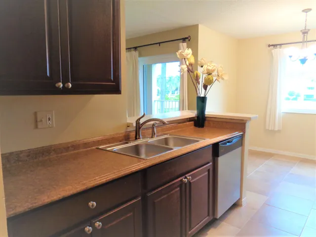a kitchen with stainless steel appliances kitchen island granite countertop a refrigerator a stove and a sink