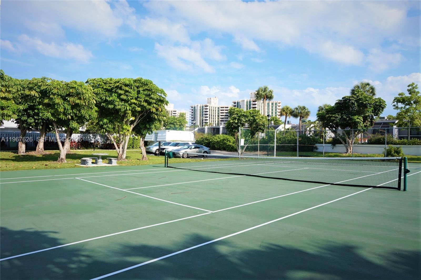 210 Seaview Drive, Unit 408 Key Biscayne, FL 33149 - Photo 28 of 34 a view of a tennis ground with large trees