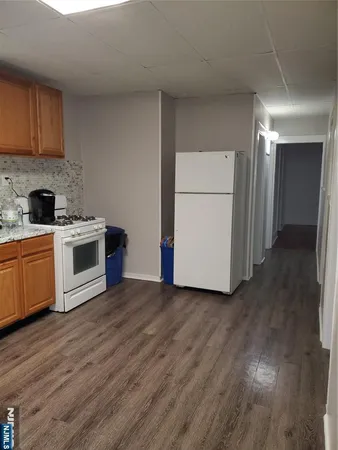 a view of a kitchen with a sink stove cabinets and empty room