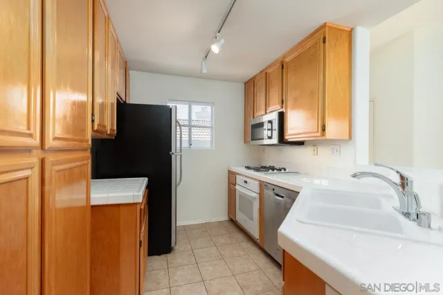 a kitchen with stainless steel appliances granite countertop a refrigerator and a sink