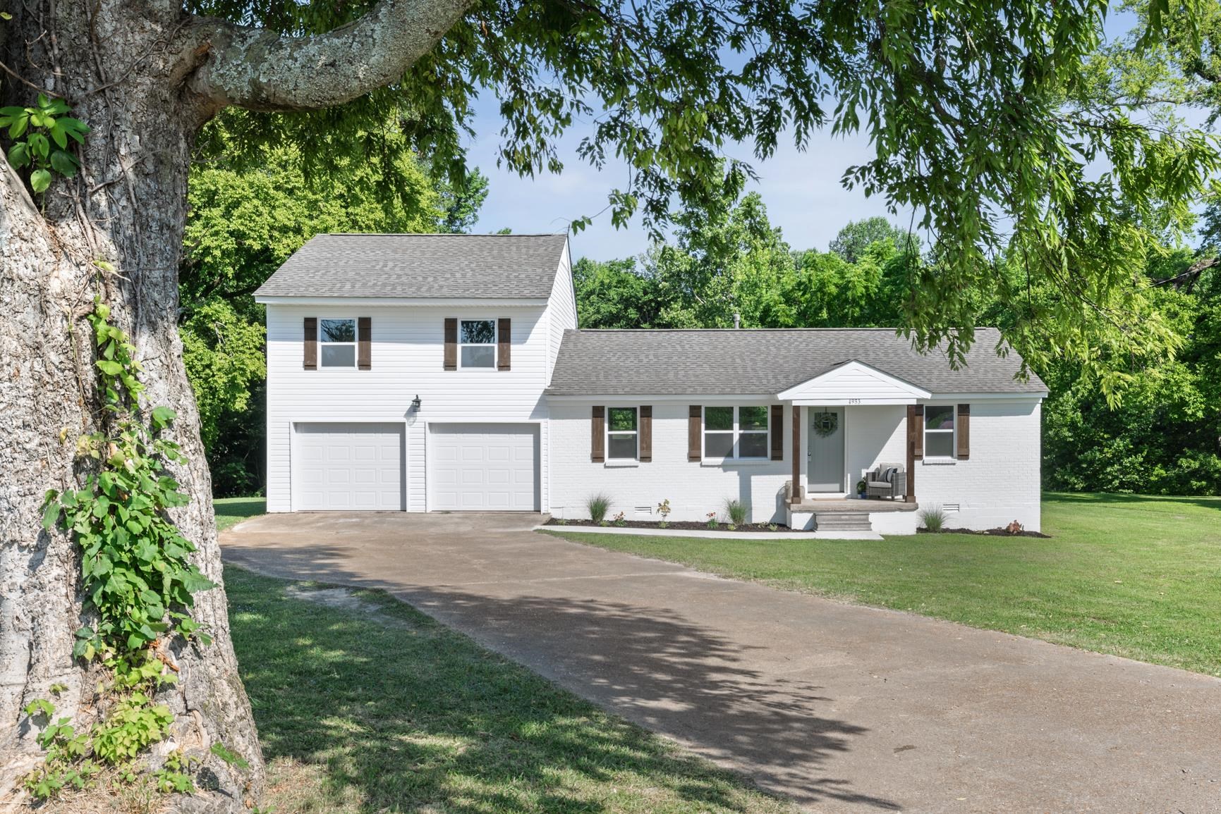 a front view of a house with a yard and trees