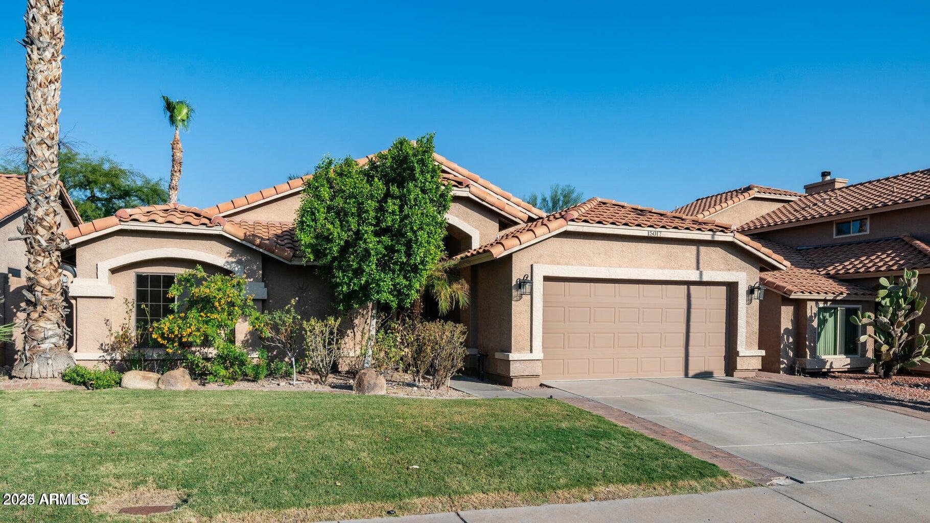 15017 South 25th Way Phoenix, AZ 85048 - Photo 1 of 18 a front view of a house with a garden and plants
