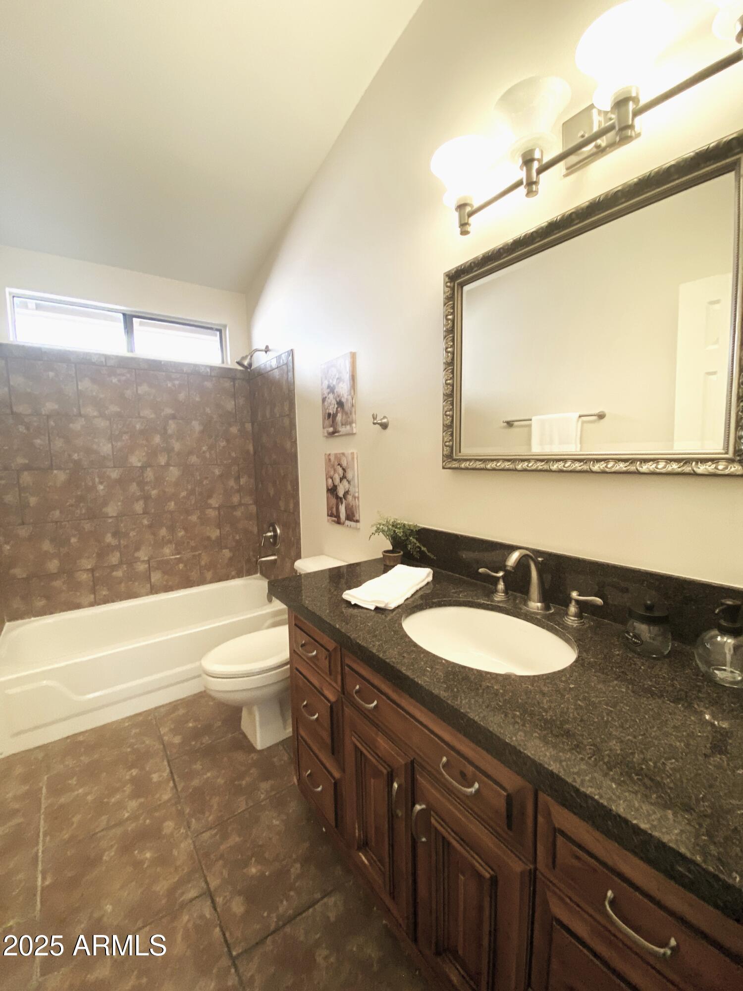 15017 South 25th Way Phoenix, AZ 85048 - Photo 13 of 18 a bathroom with a granite countertop sink a toilet and a large mirror