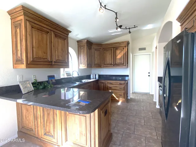 a kitchen with granite countertop a stove refrigerator and cabinets