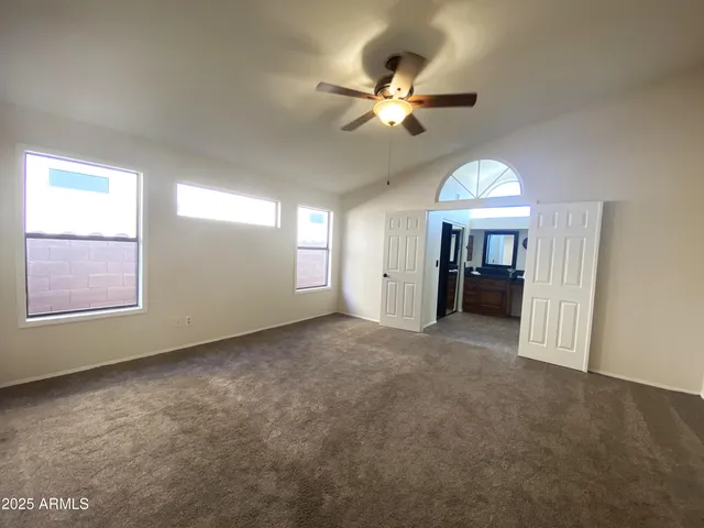 an empty room with windows and fan