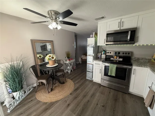 a kitchen with a table chairs a stove and microwave