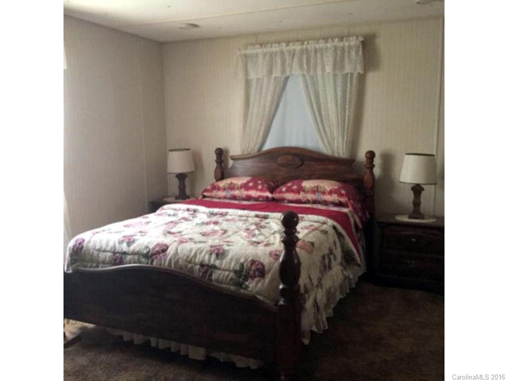 8508 Alarka Road Bryson City, NC 28713 - Photo 6 of 13 a bed sitting in a bedroom next to a window