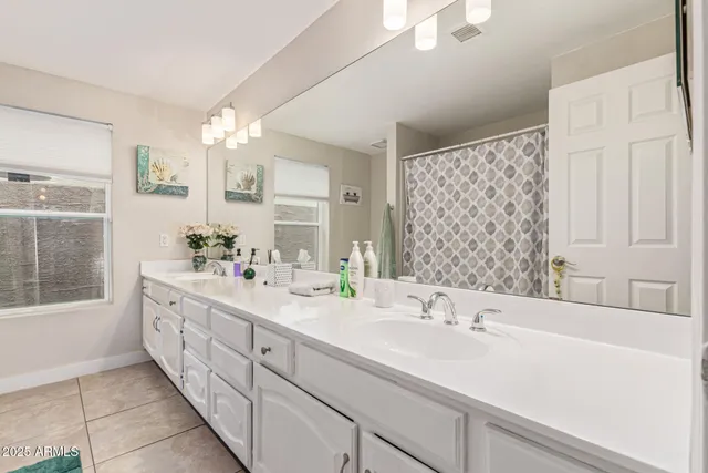 a bathroom with double vanity sinks and a mirror