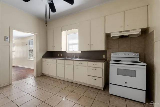a kitchen with granite countertop white cabinets and white appliances