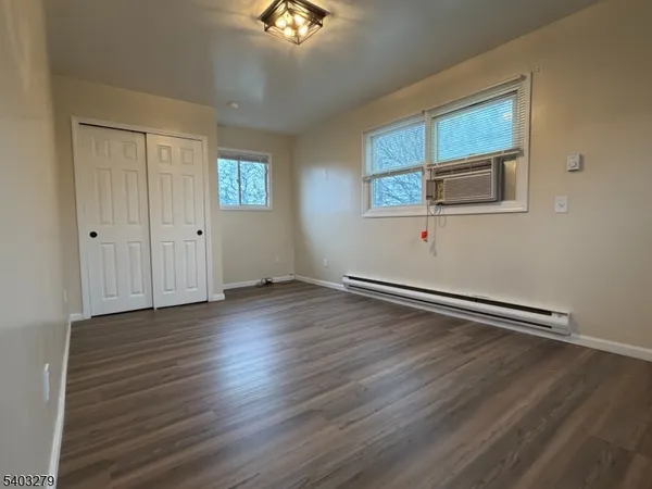 a view of a room with wooden floor and window
