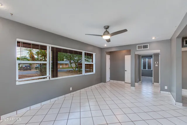 a view of an empty room with a window and a kitchen