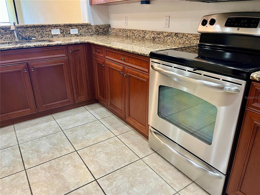 1340 Rock Dove Court, Unit 144 Punta Gorda, FL 33950 - Photo 7 of 7 a kitchen with granite countertop a stove a sink and a microwave