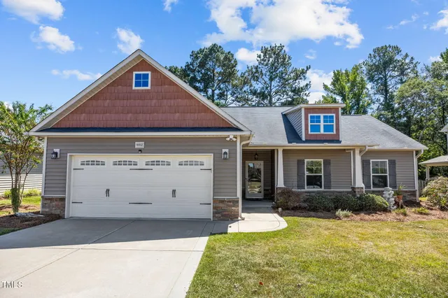 a front view of a house with yard and garage
