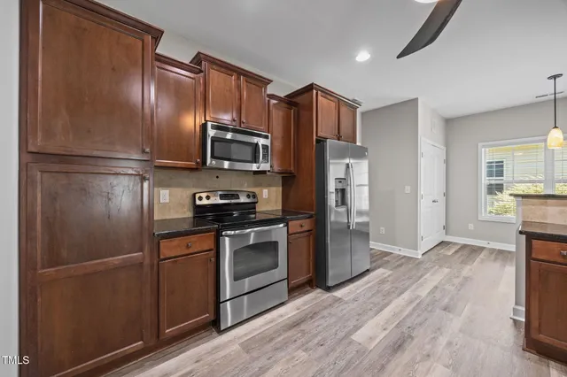 a kitchen with stainless steel appliances granite countertop wooden cabinets a sink and dishwasher