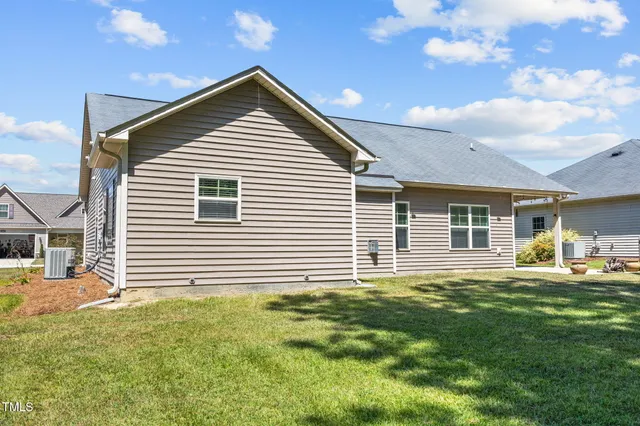 a front view of a house with a garden and trees