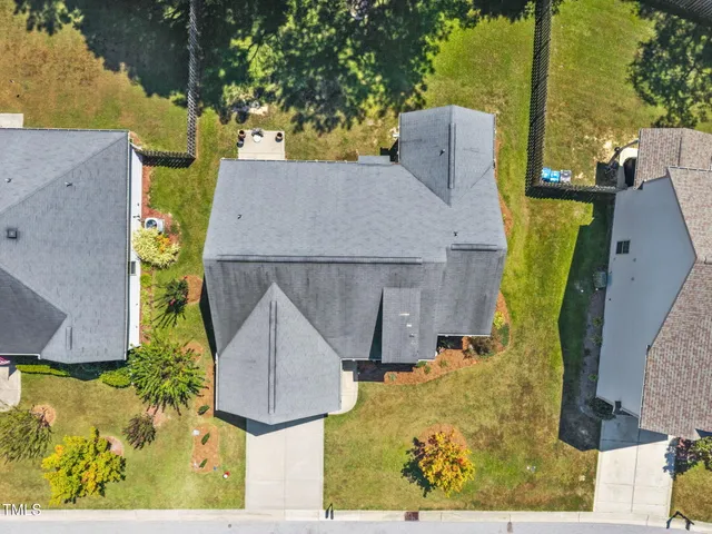 an aerial view of a house with swimming pool and large trees