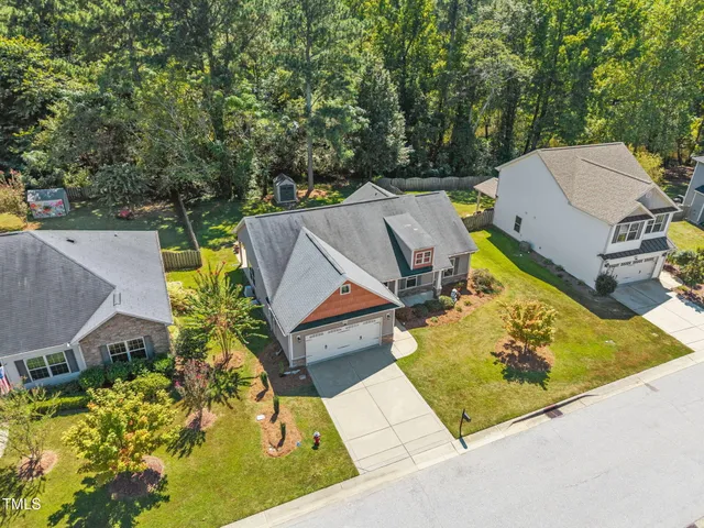 an aerial view of a house with swimming pool and large trees