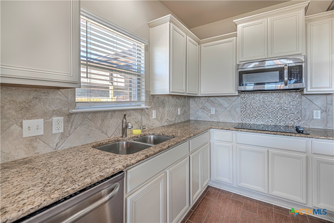 9207 Lake Pointe Drive Temple, TX 76502 - Photo 13 of 42 a kitchen with stainless steel appliances granite countertop a sink a microwave and cabinets